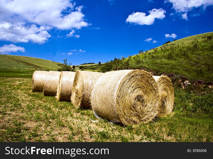 Hay Bales stacked in a field at the foot of the hills