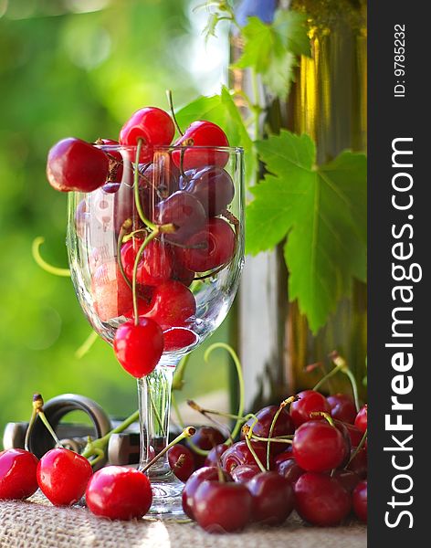 Bottle and glass of white wine and cherries. Bottle and glass of white wine and cherries.
