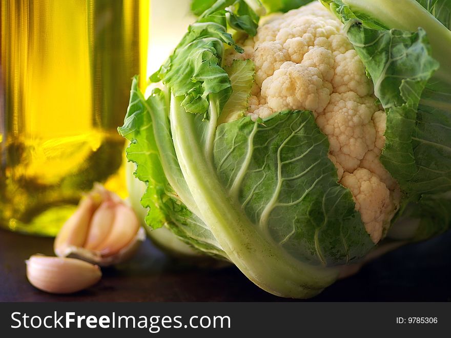 Bottle of olive oil and vegetables.