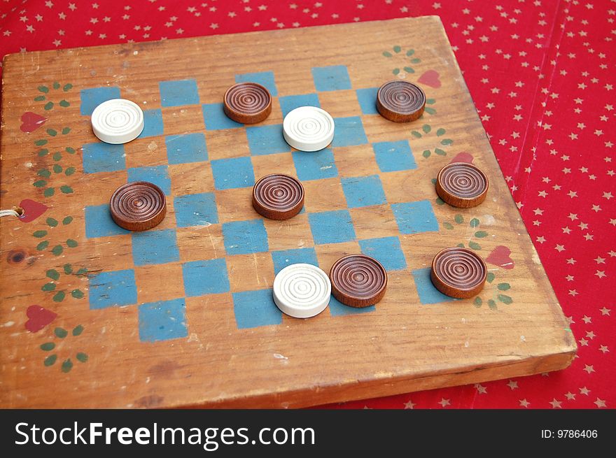 A vintage checkers game shows signs of wear from years of use. A vintage checkers game shows signs of wear from years of use