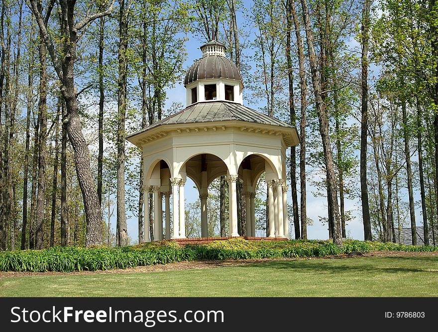 Horizontal view of garden gazebo surrounded with the early new spring growth. Horizontal view of garden gazebo surrounded with the early new spring growth.