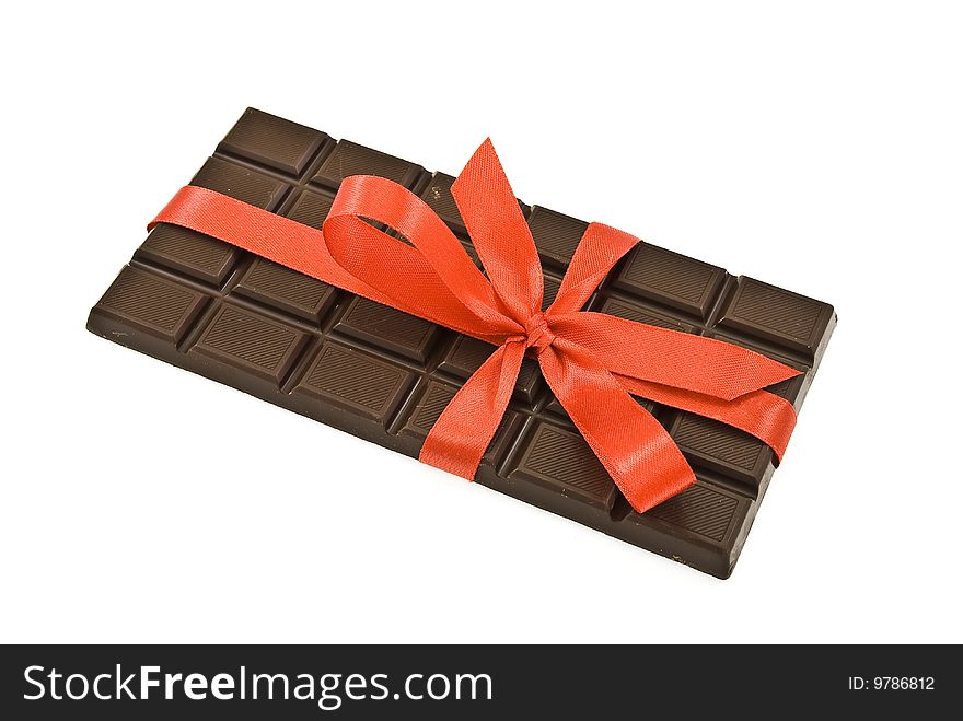 Black chocolate with red ribbon and bow isolated on white