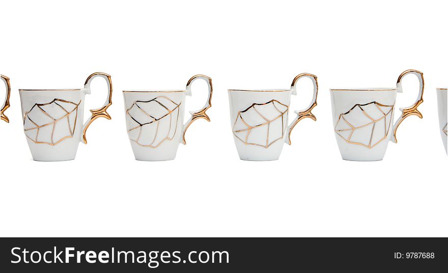 Row of white coffee cups with golden leaf isolated