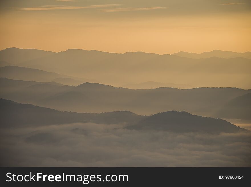 Layer of mountains and mist during sunset