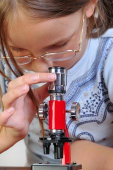 Girl Studying Something With Microscope Royalty Free Stock Photography