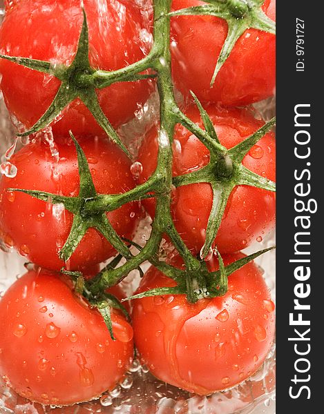 Tomatoes are under water in a kitchen, background