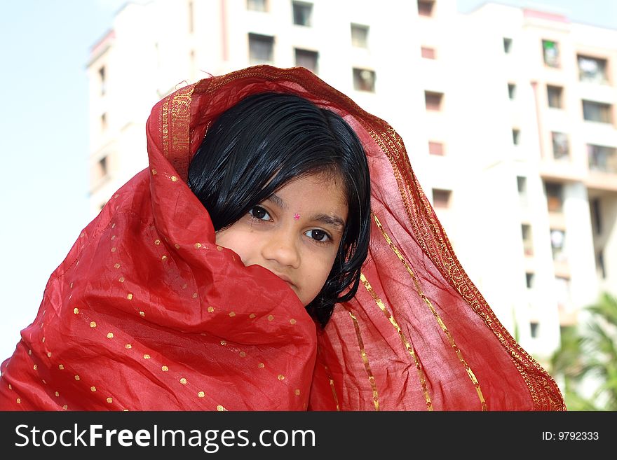 A village girl wrapped up in a red bridal saree. A village girl wrapped up in a red bridal saree.