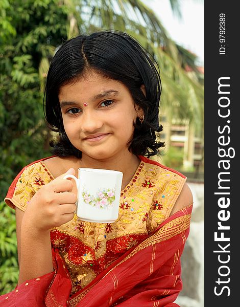 A beautiful Indian girl having a sip of morning tea. A beautiful Indian girl having a sip of morning tea.