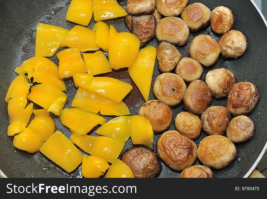 Cooking peppers and mushrooms in a pan