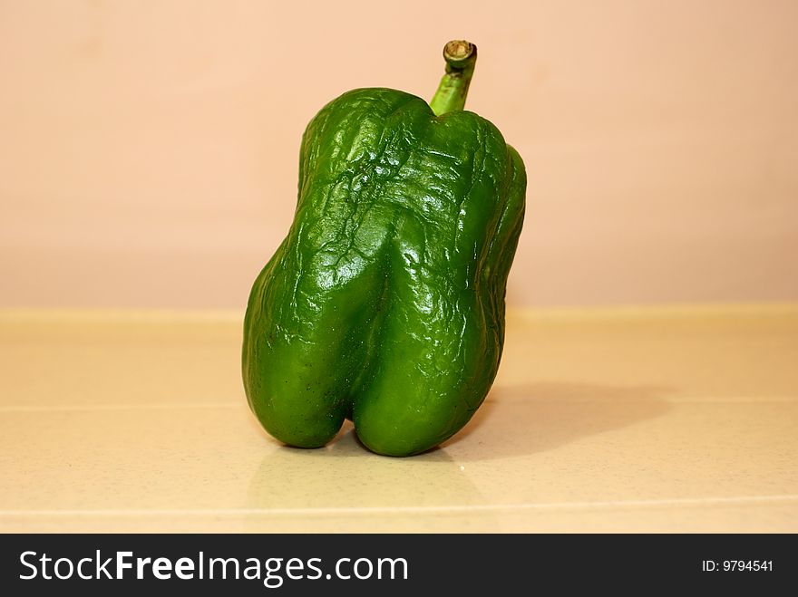 A green capsicum, because of lack of preservation has wrinkled. A green capsicum, because of lack of preservation has wrinkled.