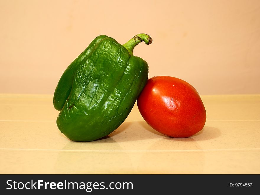 Two colorful vegetables are good friends-green capsicum and red tomato. Two colorful vegetables are good friends-green capsicum and red tomato.