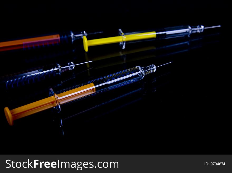 Color syringe on black background