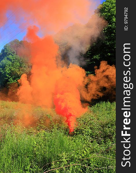 Volumes of orange smoke above a forest glade in a clear sun day. Volumes of orange smoke above a forest glade in a clear sun day