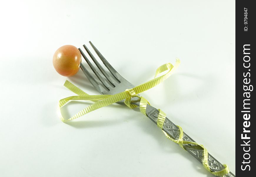 Tomato on a fork wrap with a ribbon. Tomato on a fork wrap with a ribbon