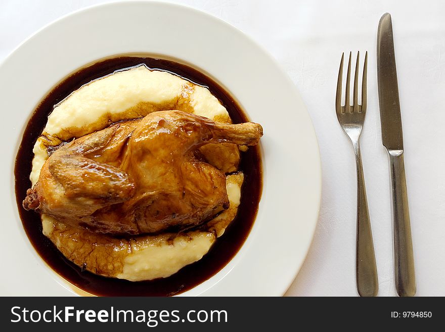 Roasted chicken and mashed potatoes on a dish at restaurant