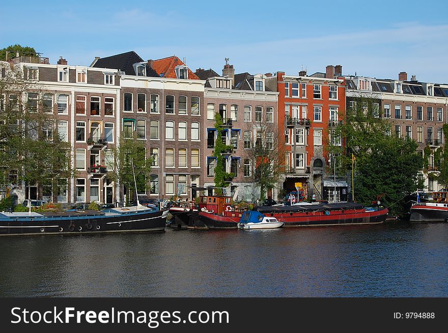 Old Canal Houses In Amsterdam At The Water