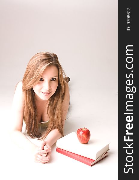 Young and beautiful student with apple and books