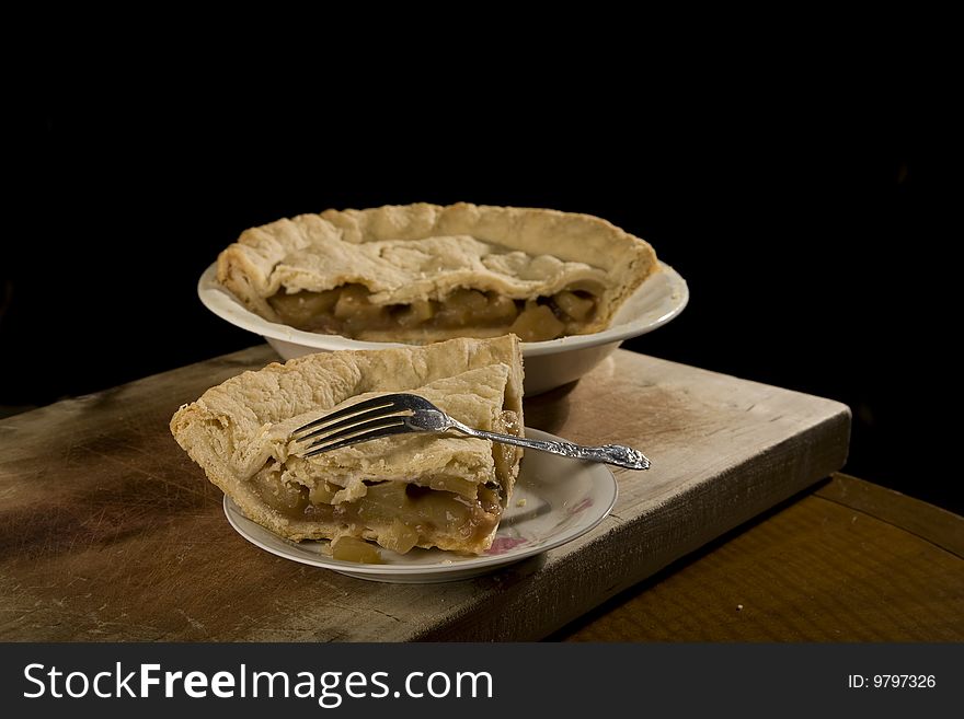 Apple pie with slice of apple pie on plate with fork. Apple pie with slice of apple pie on plate with fork.