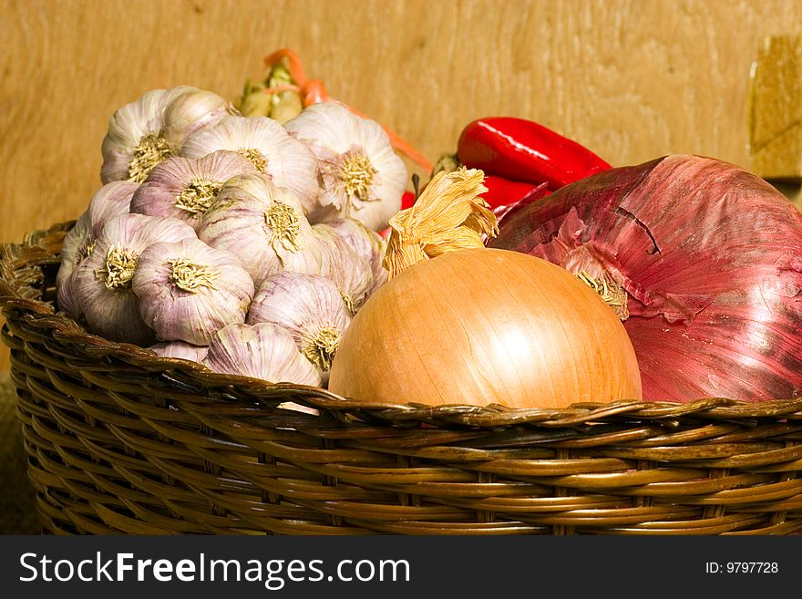 onions and garlic in a wicker basket on a shelf in the storage room. onions and garlic in a wicker basket on a shelf in the storage room