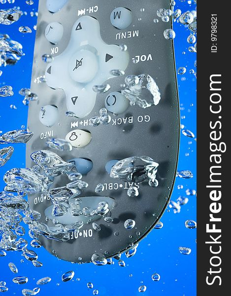 TV remote in water. Creative bubbles. Blue background