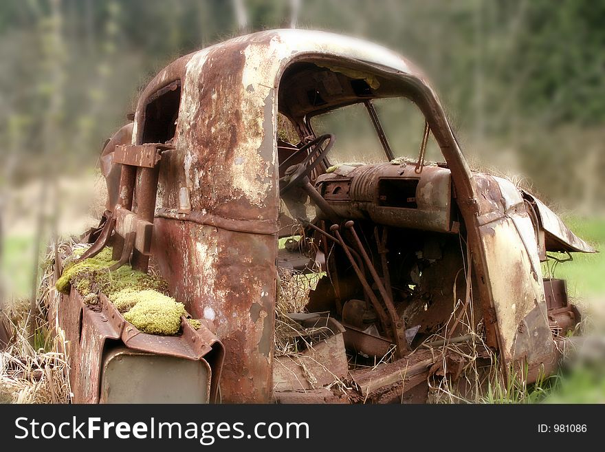 Rusting derelict truck in field.