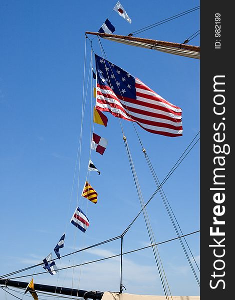 An old version of ts Unitted States Flag flies from a loine on a tall ship. An old version of ts Unitted States Flag flies from a loine on a tall ship