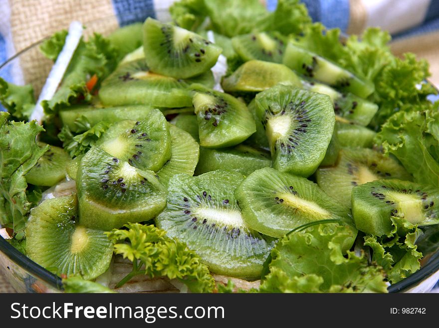 Kiwi salad with lettuce leaves and sliced kiwifruit
