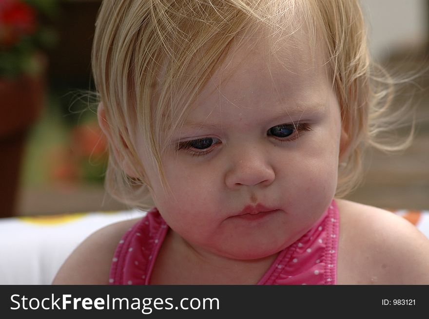 A portrait of an adorable baby girl who is deep in thought.