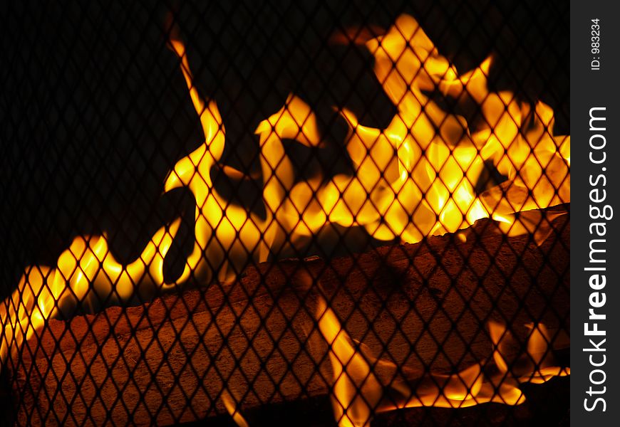 Closeup of Outdoor Firepit - flames and wood behind a grate