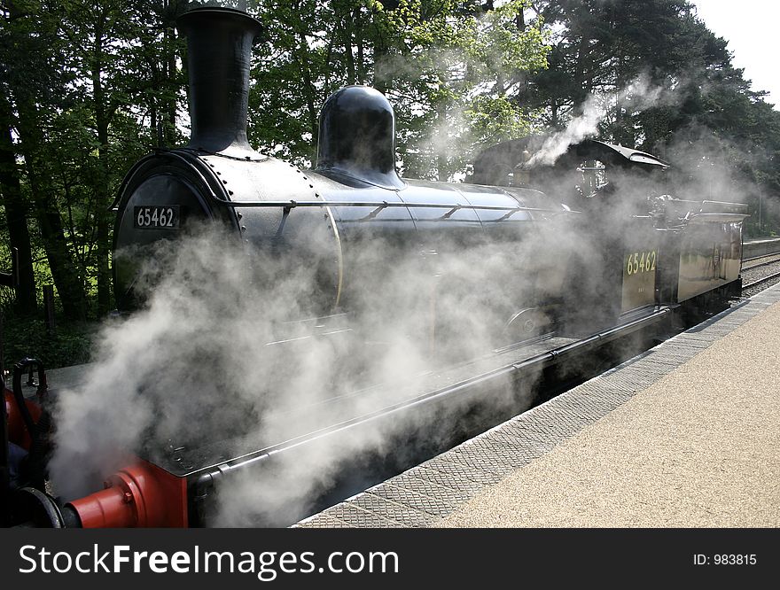 Steam engine creating alot of steam around its base. Steam engine creating alot of steam around its base