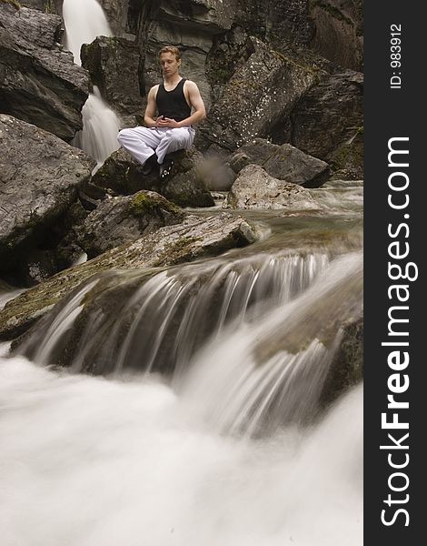 Man meditating on a stream with his katana on laps after practicing fencing skills. Man meditating on a stream with his katana on laps after practicing fencing skills