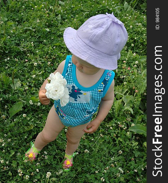 Little girl in lilac hat with white flower