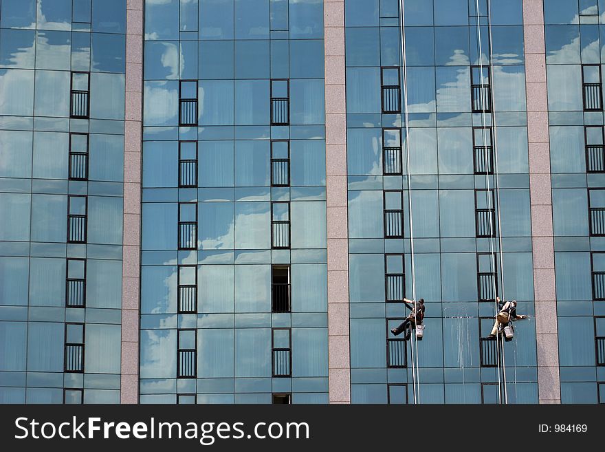 Window cleaners, cleaning skyscraper window.