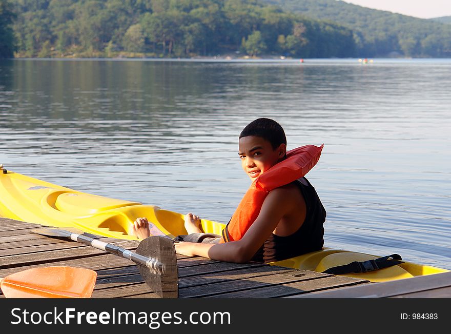 Teenager at the lake in a kayak, late afternoon