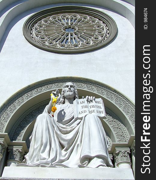 A scrupture of Jesu Magister located in front of a church