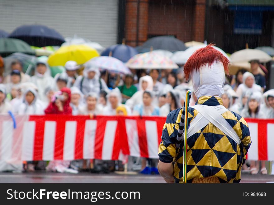 A lone performer at the Gion Festival in Kyoto facing a crowd of onlookers. A lone performer at the Gion Festival in Kyoto facing a crowd of onlookers.