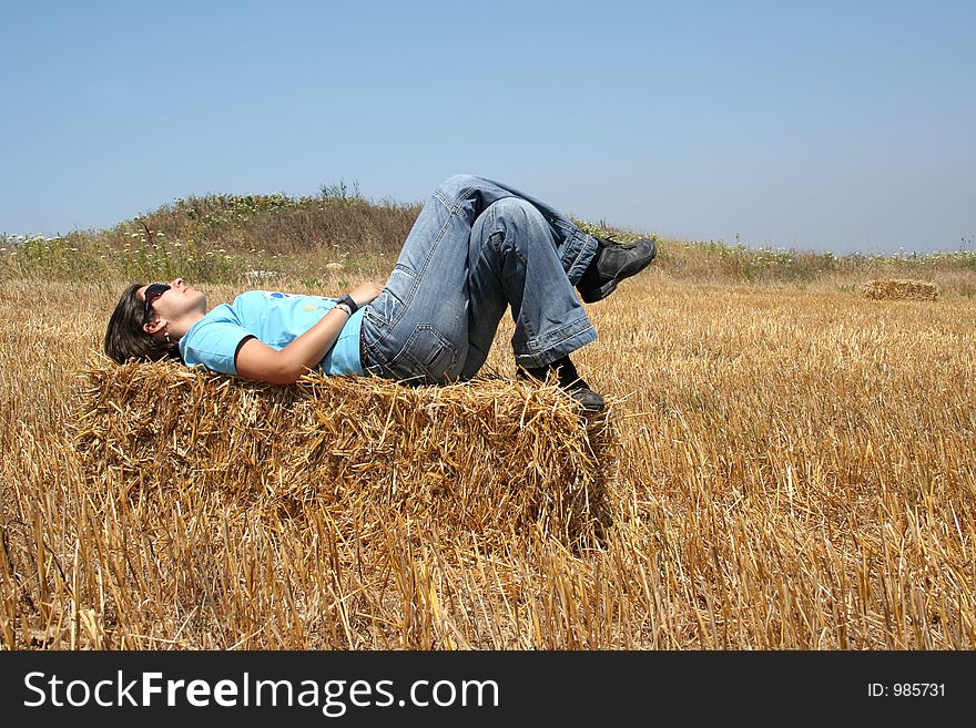 Girl laying down in a stack of hay. Girl laying down in a stack of hay