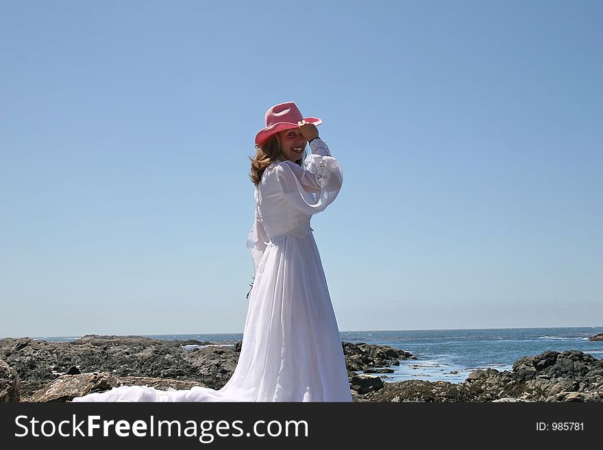 Cowgirl bride standing at ocean. Cowgirl bride standing at ocean