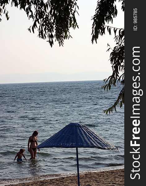 Little girl and her mother are walking in sea.