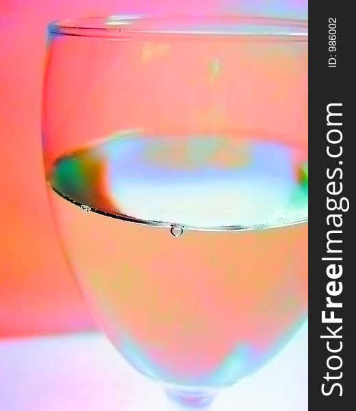 A photograph of a glass of cold water with saturated colors showing condensation on the glass. A photograph of a glass of cold water with saturated colors showing condensation on the glass.