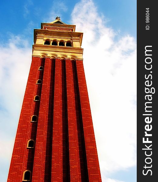 A photograph of a tower in Italy with a bright cloudy sky background. A photograph of a tower in Italy with a bright cloudy sky background.