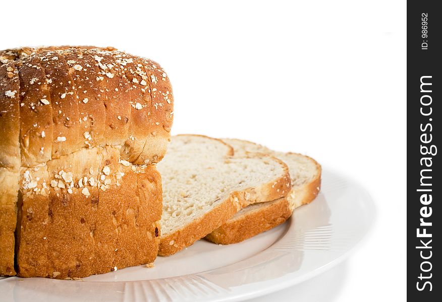 Loaf of sliced bread on plate. Isolated on white.