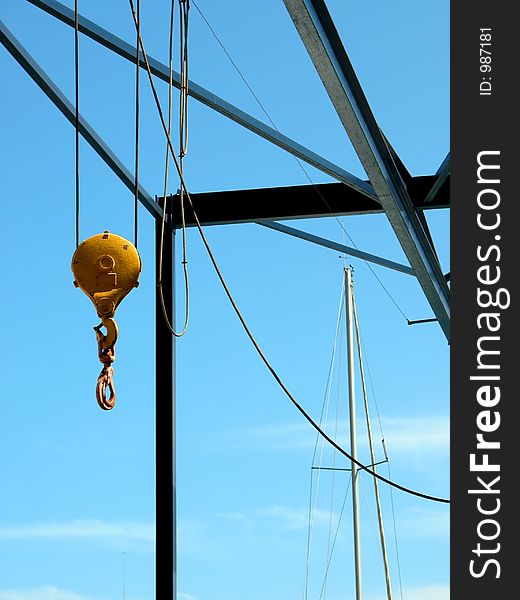 Yellow boat crane contrasting with blue sky