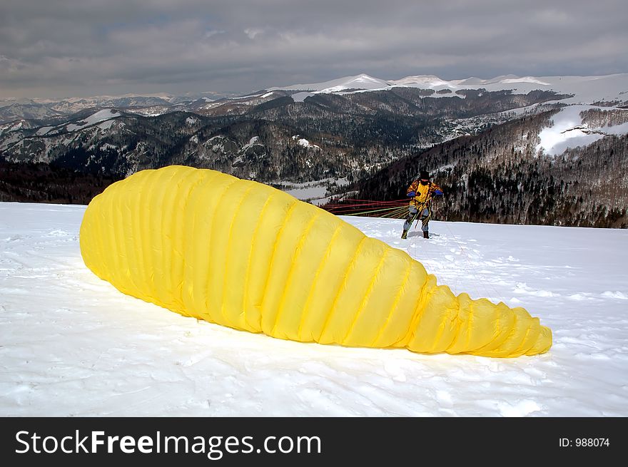 Yellow paraglider preparing for flight