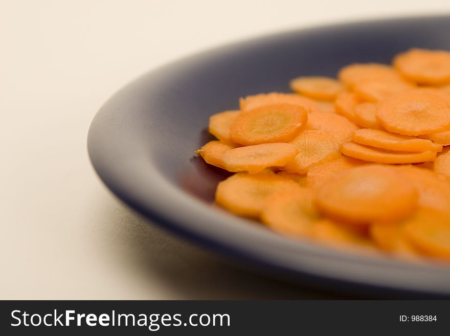 Carrot, sliced by circles on a blue plate