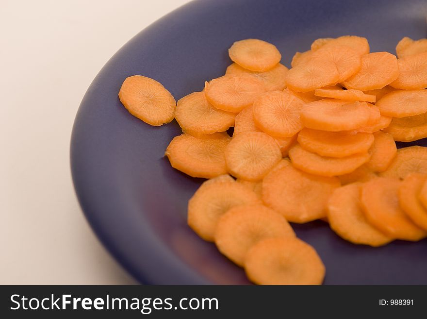 Carrot, sliced by circles on a blue plate