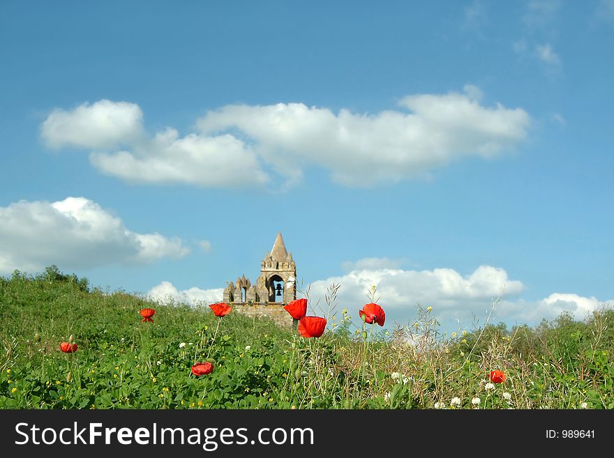 Old church tower in poppy field