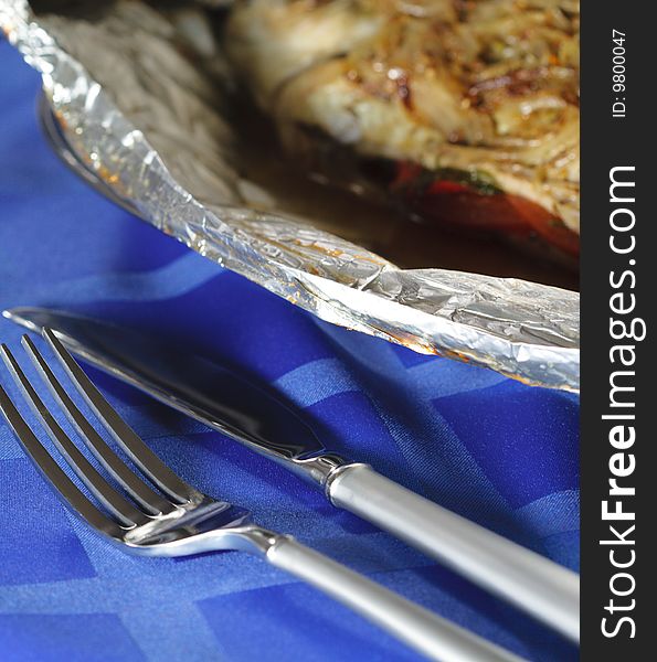 Fork and Knife and Hot Fish Dishes in Foil