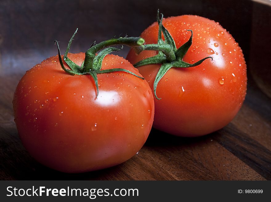 Red tomatos on a vine on dark background