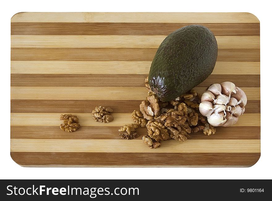 Avocado with a garlic and nuts on a wooden board